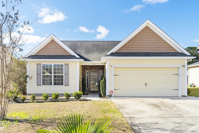 view of front of house with a garage, roof with shingles, and concrete driveway