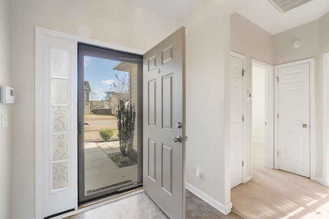 foyer entrance with visible vents and baseboards