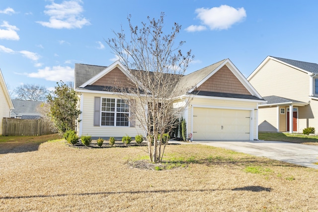 view of front of house with a front yard, an attached garage, fence, and driveway