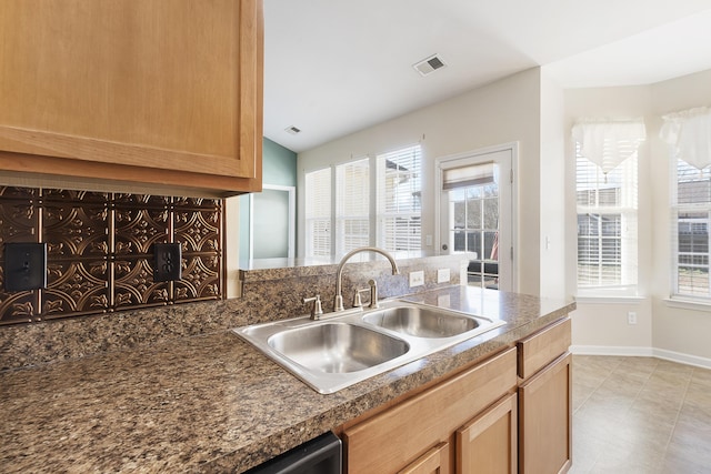 kitchen featuring dark countertops, plenty of natural light, visible vents, and a sink