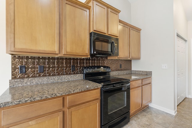 kitchen with black appliances, light brown cabinets, backsplash, dark stone counters, and baseboards