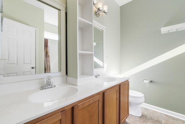 full bath with double vanity, toilet, baseboards, and a sink