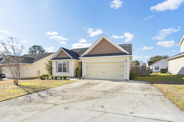 view of front of house with concrete driveway, an attached garage, fence, and a front yard