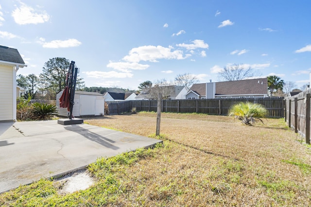 view of yard featuring a patio area, an outbuilding, a fenced backyard, and a shed