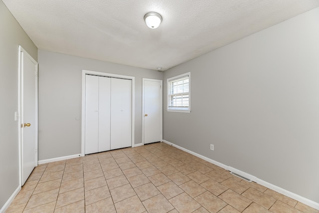 unfurnished bedroom featuring a textured ceiling and a closet