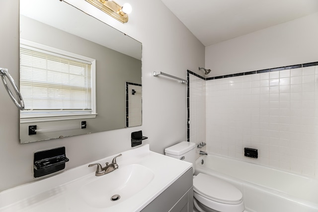 full bathroom with vanity, tiled shower / bath combo, and toilet