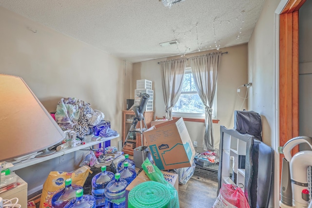 miscellaneous room featuring hardwood / wood-style flooring and a textured ceiling