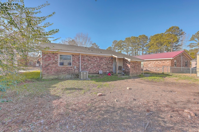 rear view of property featuring a yard and central AC unit