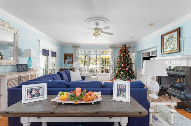 living area with french doors, wood finished floors, a fireplace, and crown molding