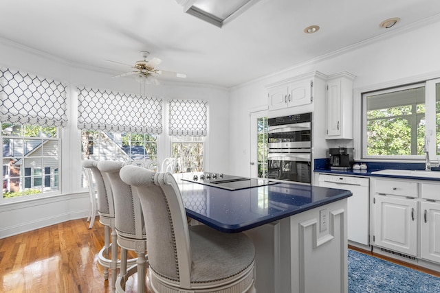 kitchen featuring double oven, white cabinetry, black electric stovetop, and white dishwasher