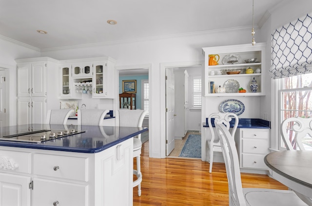 kitchen featuring light wood-type flooring, ornamental molding, open shelves, white cabinetry, and black electric cooktop