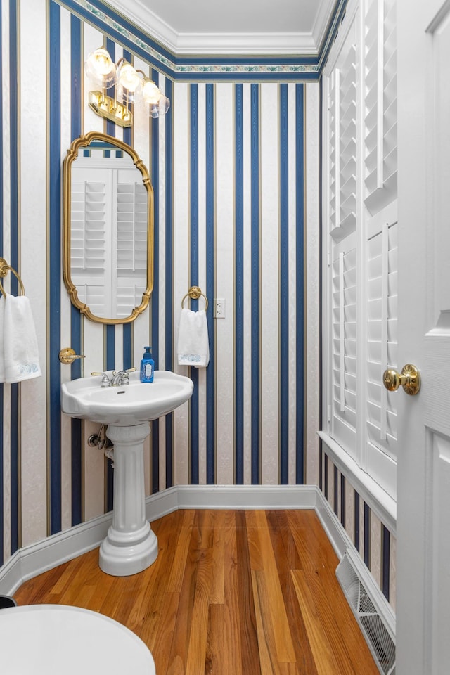 bathroom with visible vents, wallpapered walls, baseboards, and wood finished floors