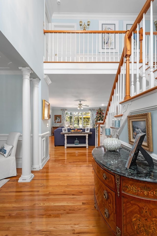 interior space featuring decorative columns, ornamental molding, and stairs