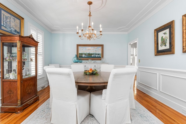 dining space with plenty of natural light, light wood-style floors, and ornamental molding