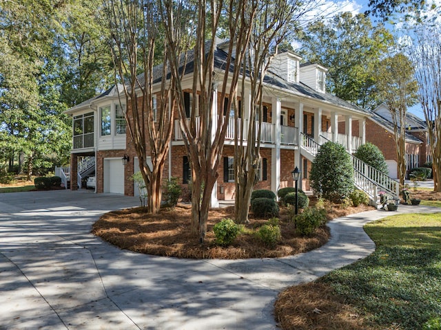 view of front of property with a garage, brick siding, concrete driveway, and stairs