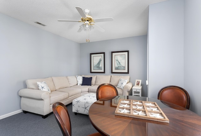 living area featuring visible vents, baseboards, carpet flooring, a textured ceiling, and a ceiling fan