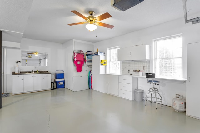 garage featuring a ceiling fan and a sink