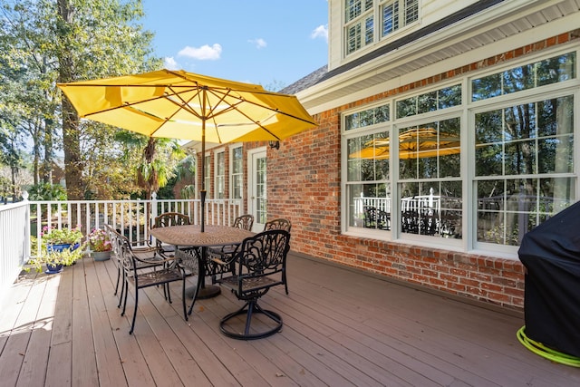 wooden terrace with area for grilling and outdoor dining space