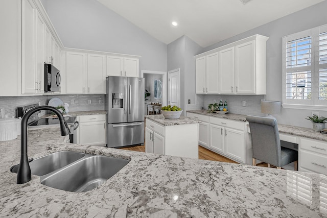 kitchen with vaulted ceiling, white cabinets, a sink, and stainless steel fridge with ice dispenser