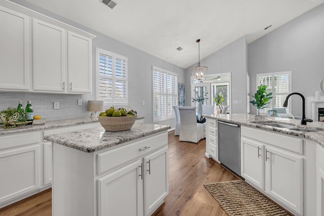 kitchen with visible vents, dishwasher, lofted ceiling, light wood-type flooring, and a sink