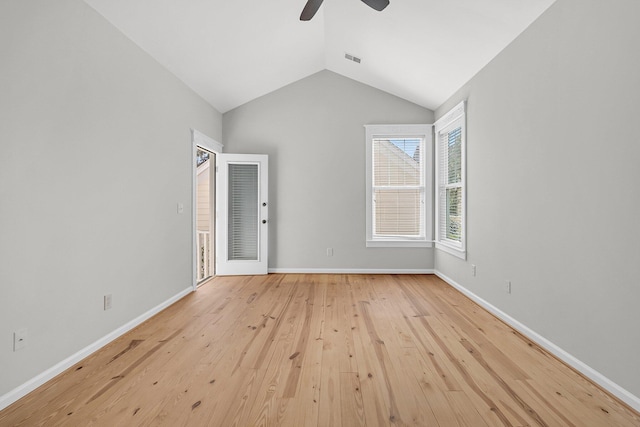 spare room featuring visible vents, baseboards, ceiling fan, light wood-style flooring, and vaulted ceiling