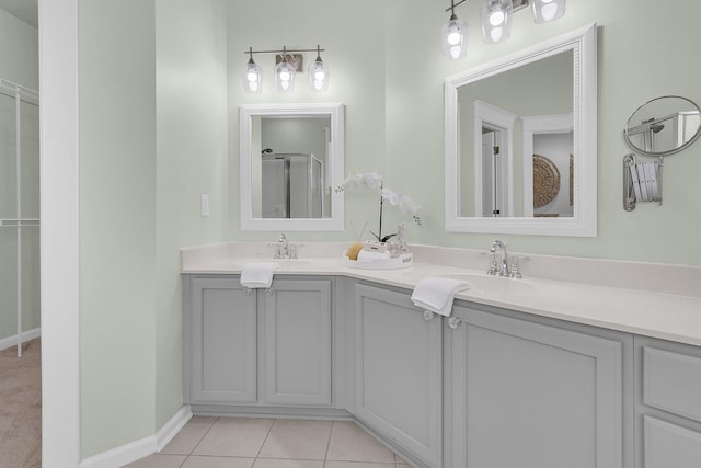 full bathroom with tile patterned flooring, a sink, baseboards, and double vanity