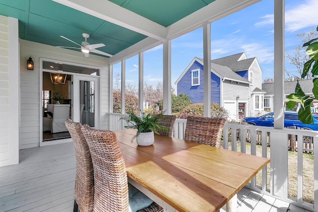 sunroom with ceiling fan with notable chandelier