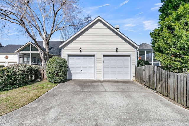 garage with driveway and fence