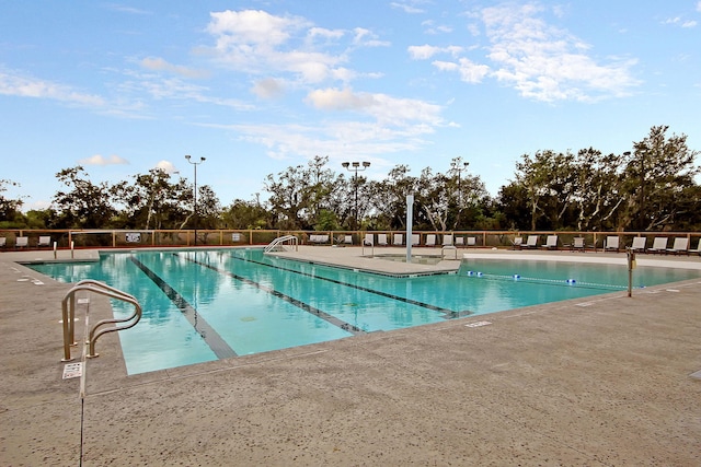 pool with a patio and fence