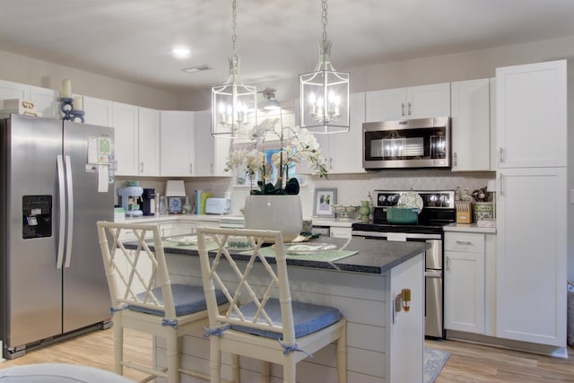 10 Teaneck Rd, Goose Creek, SC 29445 - kitchen featuring stainless steel appliances, white cabinetry, light wood-type flooring, decorative backsplash, and a center island