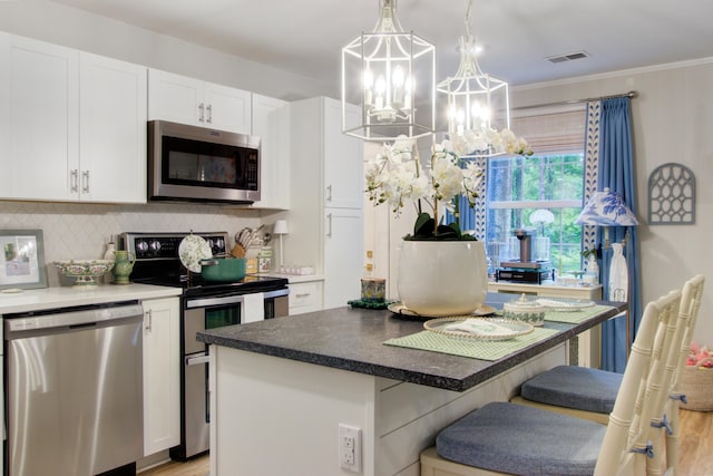 10 Teaneck Rd, Goose Creek, SC 29445 - kitchen with stainless steel appliances, backsplash, white cabinets, a kitchen island, and a chandelier