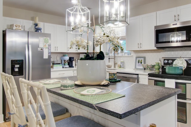 10 Teaneck Rd, Goose Creek, SC 29445 - kitchen featuring appliances with stainless steel finishes, tasteful backsplash, white cabinetry, and a breakfast bar