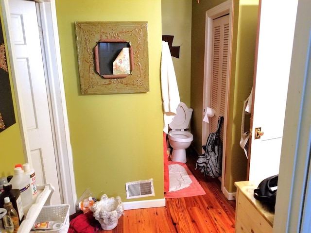 bathroom with hardwood / wood-style flooring and toilet