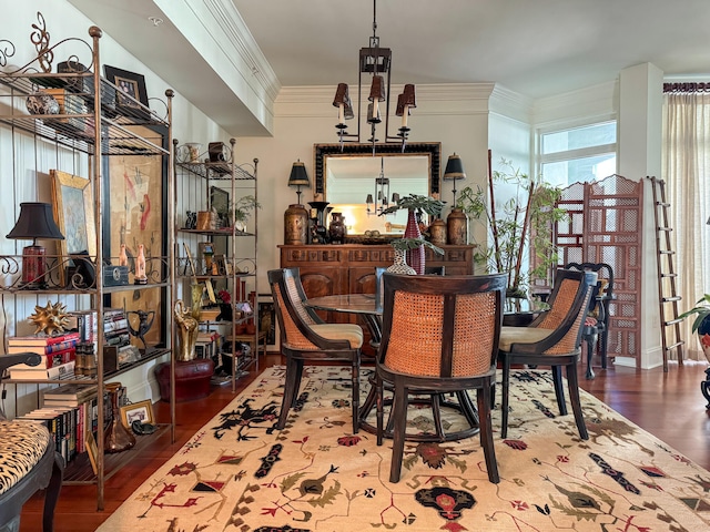 dining room with hardwood / wood-style flooring, crown molding, and a chandelier