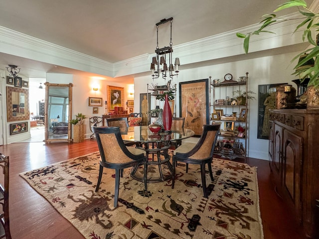 dining area with wood-type flooring, a notable chandelier, and ornamental molding