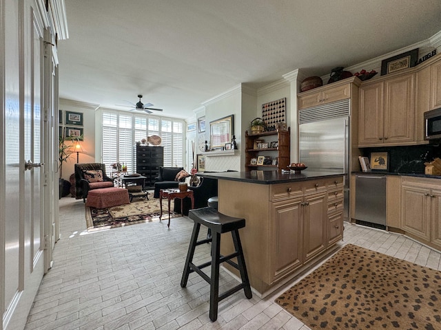 kitchen featuring ceiling fan, stainless steel appliances, tasteful backsplash, a breakfast bar, and a kitchen island