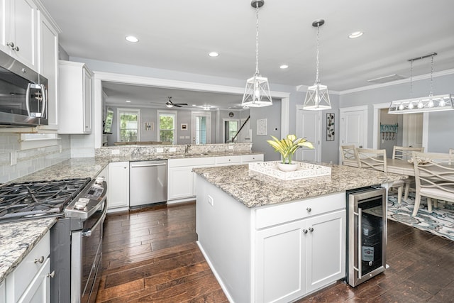 kitchen featuring stainless steel appliances, wine cooler, dark wood-type flooring, a sink, and recessed lighting