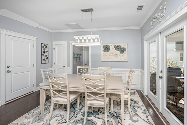 dining area with dark wood-type flooring and crown molding