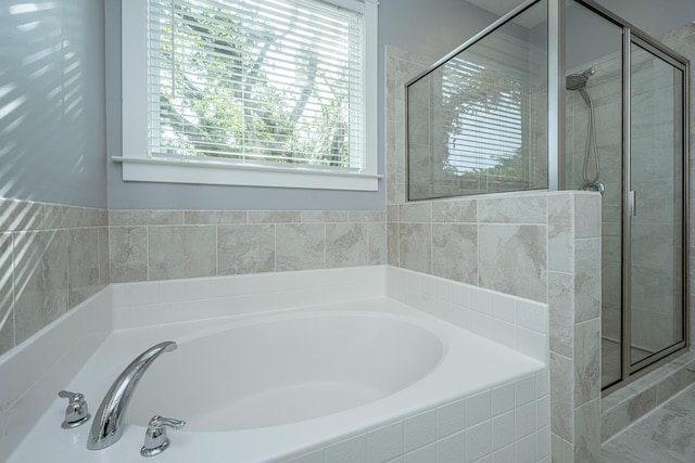 full bathroom featuring a stall shower and a garden tub