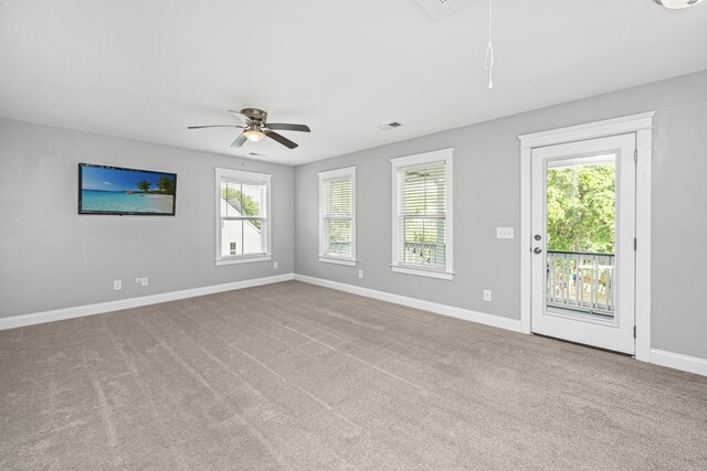 empty room featuring attic access, ceiling fan, baseboards, and carpet