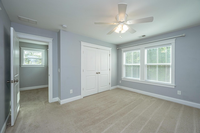 unfurnished bedroom featuring carpet, baseboards, a closet, and ceiling fan