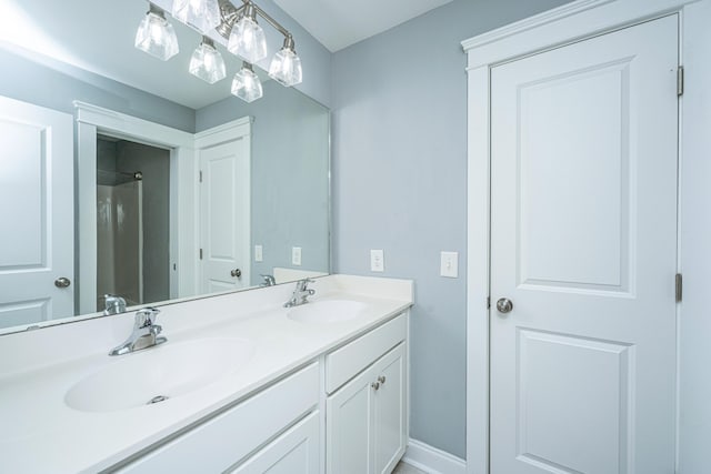 full bathroom with double vanity and baseboards