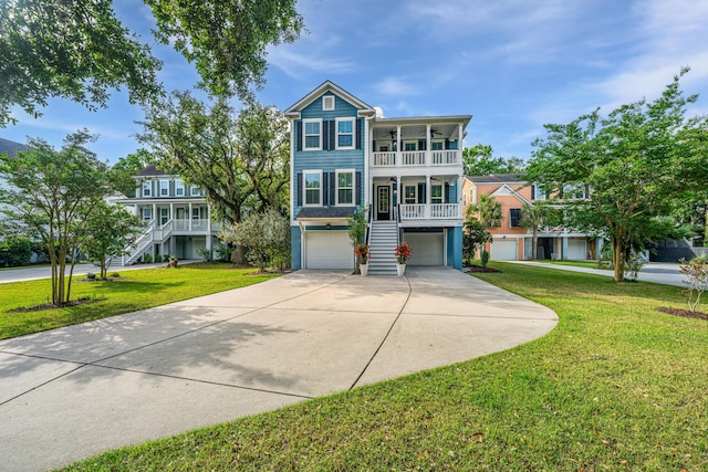 coastal home with stairway, a garage, concrete driveway, a front lawn, and a porch