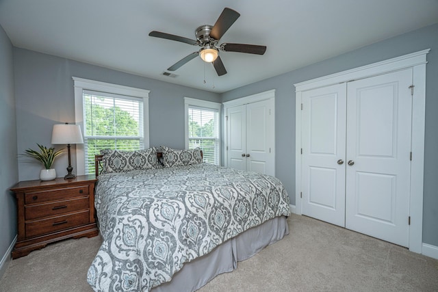 bedroom featuring multiple closets, carpet, baseboards, and a ceiling fan