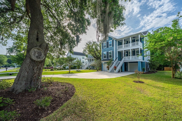 view of community with a garage, driveway, stairs, and a lawn