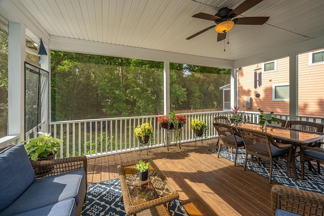 sunroom featuring a ceiling fan, outdoor dining area, and an outdoor hangout area