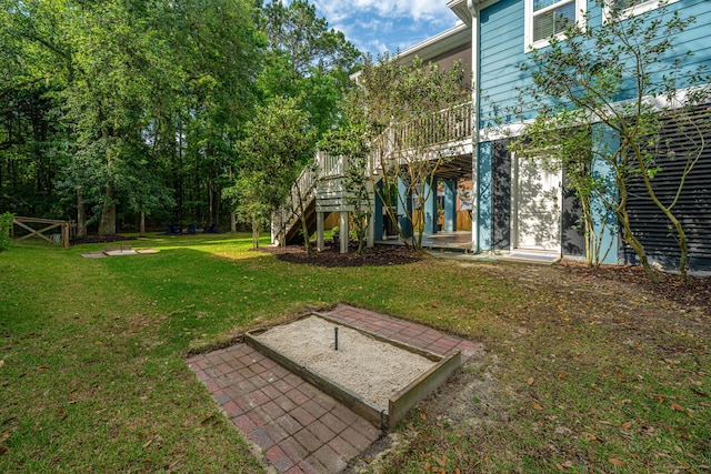 view of green lawn with stairway and a wooden deck