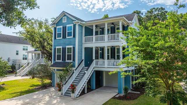 view of front of home with stairway, covered porch, a ceiling fan, and a balcony