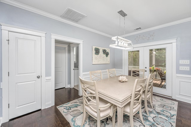 dining area featuring french doors, crown molding, dark wood-style floors, and wainscoting