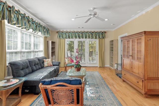 living room with ceiling fan, ornamental molding, and light wood-type flooring